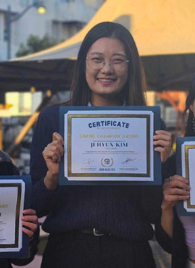 Mia Lai, Jihyun Kim and Cindy Jeon hold up their winning certificates of the Grand Champion Award